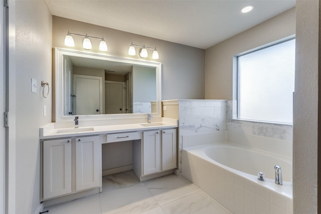 bathroom featuring tiled bath and vanity