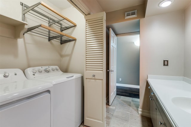 clothes washing area with washer and dryer and sink