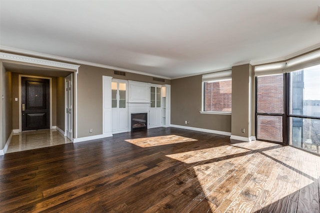 unfurnished living room featuring dark hardwood / wood-style floors and crown molding