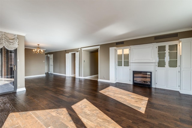 unfurnished living room with dark wood-type flooring, a notable chandelier, and crown molding