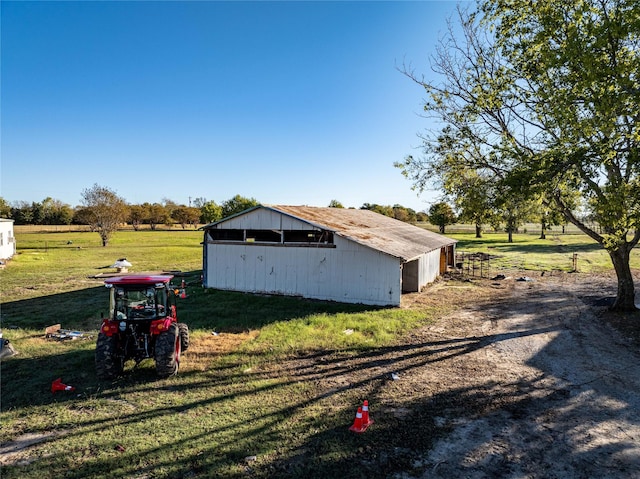 view of outbuilding with a rural view and a lawn