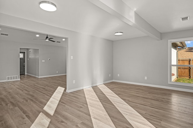 unfurnished room featuring ceiling fan, beam ceiling, and light hardwood / wood-style flooring