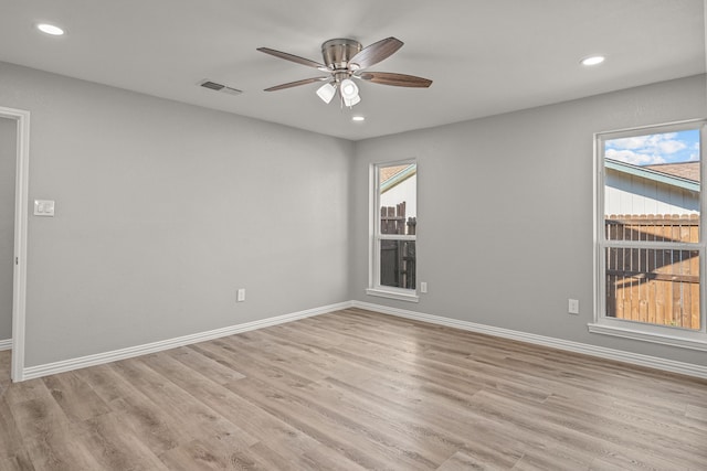 empty room with ceiling fan and light hardwood / wood-style floors