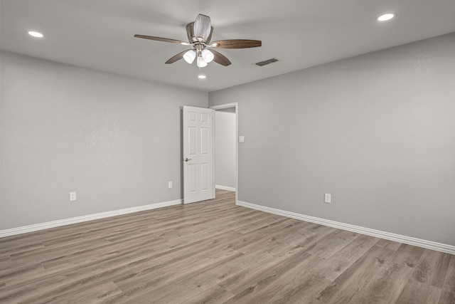 empty room with ceiling fan and light hardwood / wood-style floors