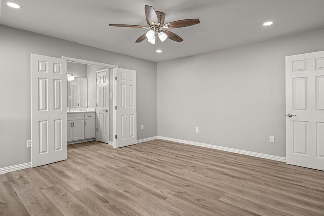 unfurnished bedroom featuring ceiling fan, light wood-type flooring, and ensuite bathroom