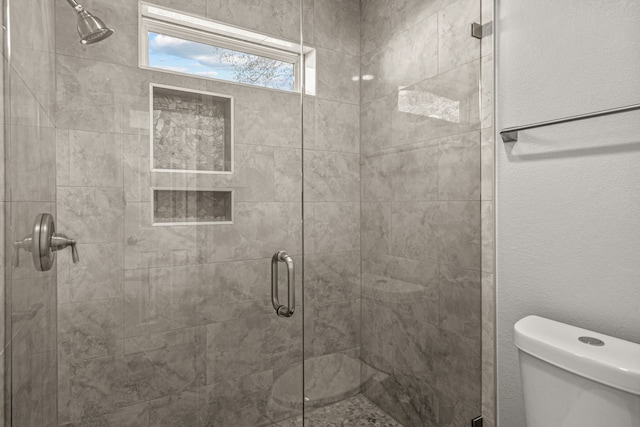 bathroom featuring an enclosed shower and toilet