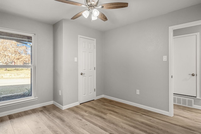 empty room with ceiling fan and light hardwood / wood-style floors