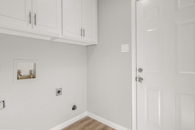 washroom with light wood-type flooring, hookup for an electric dryer, hookup for a washing machine, and cabinets