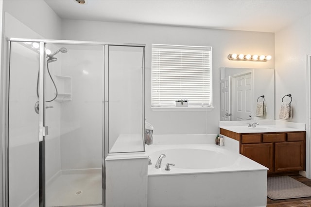 bathroom with hardwood / wood-style floors, separate shower and tub, and vanity