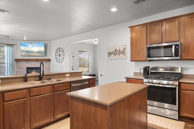 kitchen with a wealth of natural light, sink, stainless steel appliances, and a center island