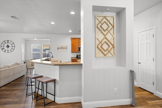 kitchen with a breakfast bar and dark hardwood / wood-style flooring