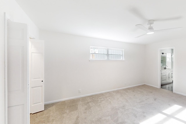 unfurnished bedroom featuring ceiling fan, light colored carpet, and connected bathroom