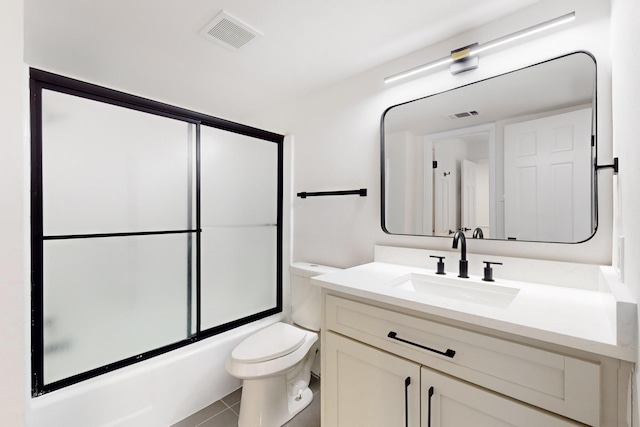 full bathroom featuring shower / bath combination with glass door, vanity, toilet, and tile patterned flooring