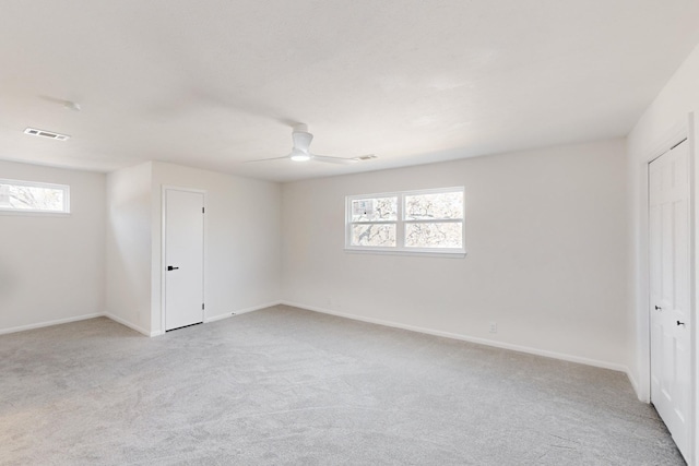 carpeted spare room with ceiling fan