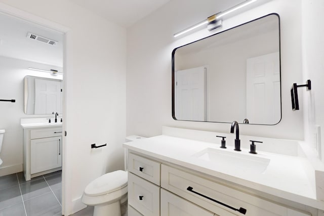 bathroom featuring toilet, tile patterned flooring, and vanity