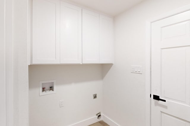 laundry room with hookup for an electric dryer, hardwood / wood-style flooring, hookup for a washing machine, and cabinets