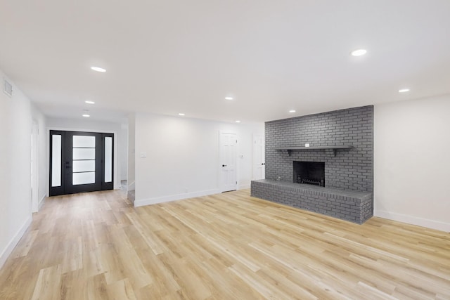 unfurnished living room with light wood-type flooring and a fireplace