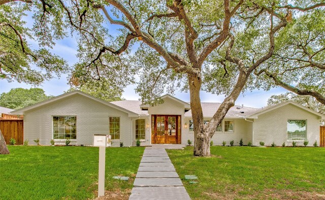 single story home featuring a front yard and french doors