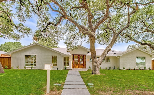 single story home featuring a front yard and french doors