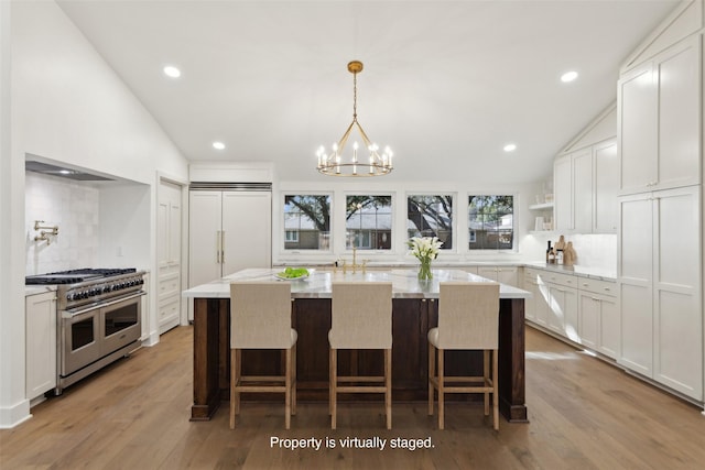 kitchen with lofted ceiling, backsplash, and high quality appliances