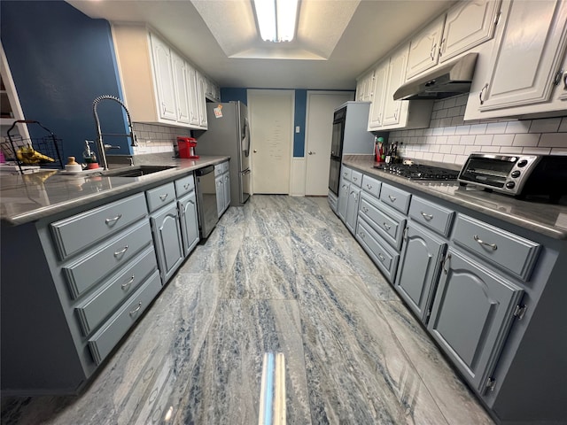 kitchen with appliances with stainless steel finishes, gray cabinetry, white cabinets, and sink