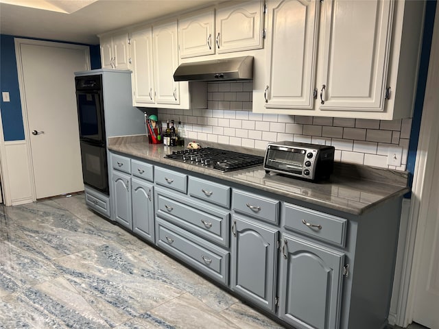 kitchen featuring stainless steel gas stovetop, gray cabinets, decorative backsplash, white cabinets, and black double oven