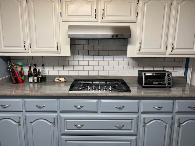 kitchen with ventilation hood, decorative backsplash, and white cabinetry