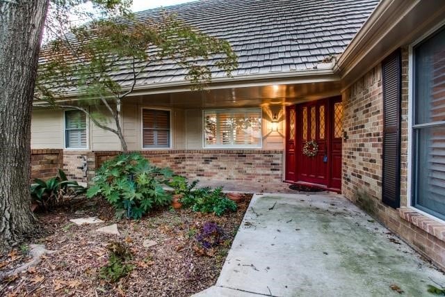 view of exterior entry with a patio area