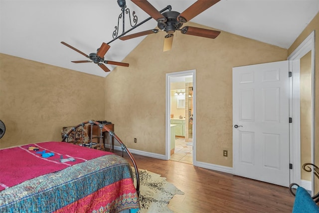 bedroom with ceiling fan, ensuite bath, wood-type flooring, and lofted ceiling