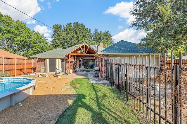 back of house with a lawn, a patio area, and a fenced in pool