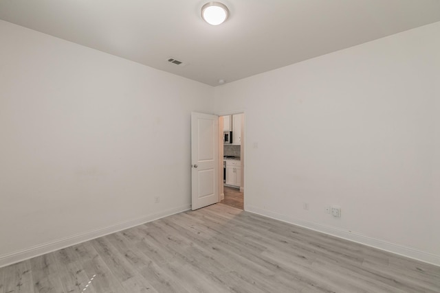 spare room featuring light hardwood / wood-style floors