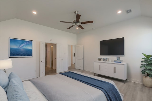 bedroom with ceiling fan, lofted ceiling, and light hardwood / wood-style floors