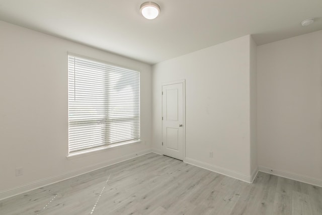 empty room featuring a wealth of natural light and light hardwood / wood-style flooring