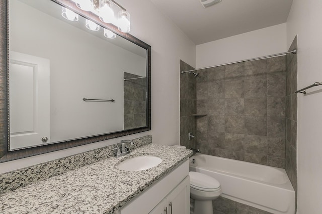 full bathroom with tile patterned floors, tiled shower / bath combo, vanity, and toilet