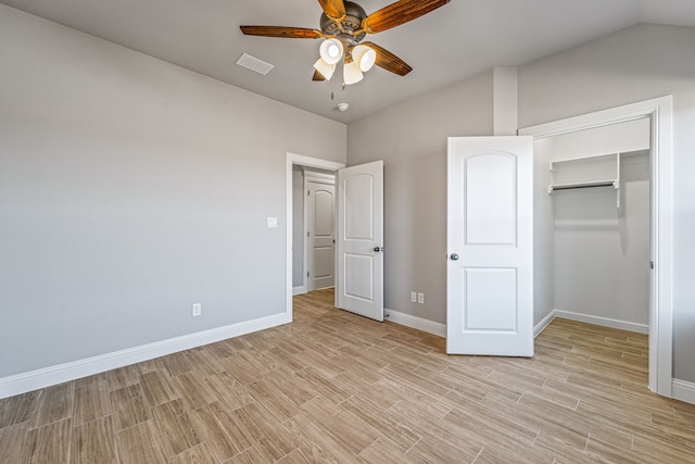 unfurnished bedroom with lofted ceiling, baseboards, visible vents, and light wood-style floors