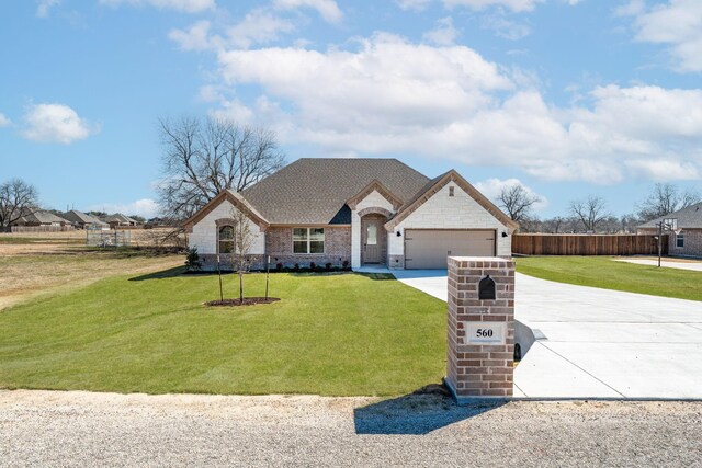 french country style house with a garage and a front yard