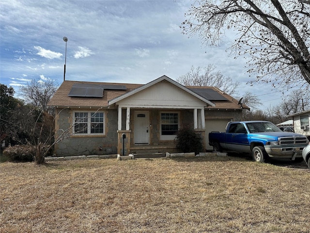 view of front of house with a garage, a front yard, and solar panels