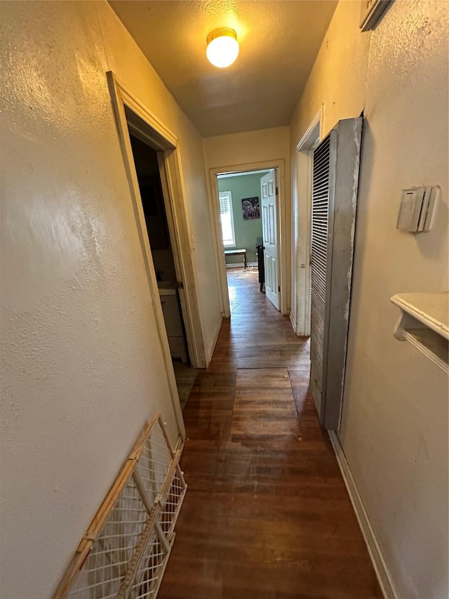 corridor with dark hardwood / wood-style flooring