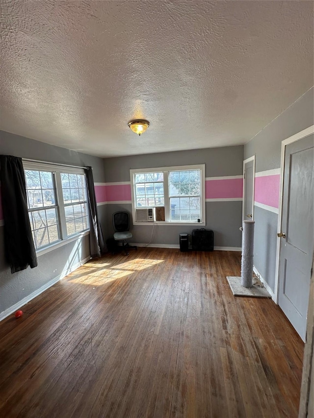 unfurnished living room featuring a textured ceiling and hardwood / wood-style floors