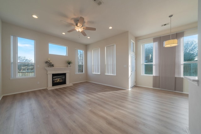 unfurnished living room with ceiling fan and light hardwood / wood-style flooring