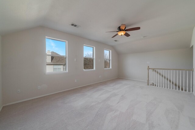 carpeted empty room with lofted ceiling