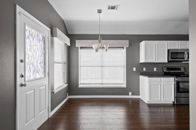 kitchen featuring vaulted ceiling, appliances with stainless steel finishes, pendant lighting, white cabinetry, and a chandelier