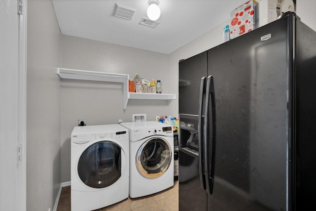 clothes washing area featuring light tile patterned floors and independent washer and dryer