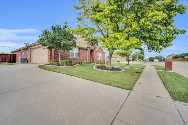 ranch-style house featuring a garage, a front yard, and central AC unit