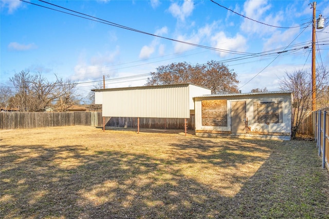 back of house with an outbuilding and a yard