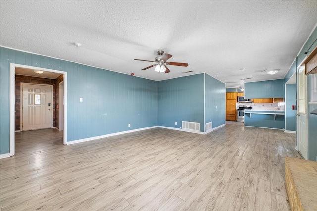 unfurnished living room featuring ceiling fan, light wood-type flooring, and a textured ceiling