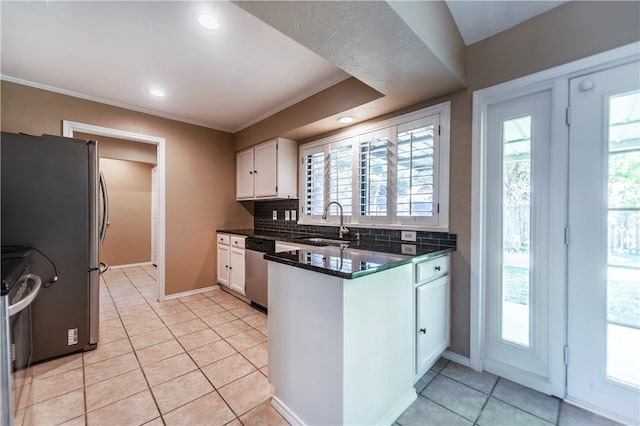 kitchen featuring light tile patterned floors, appliances with stainless steel finishes, decorative backsplash, white cabinets, and sink