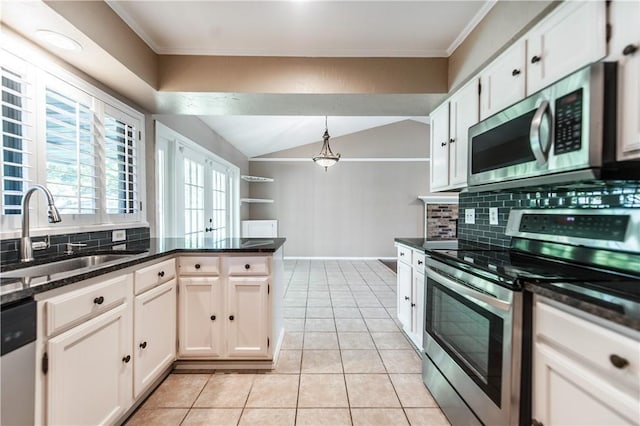 kitchen featuring pendant lighting, white cabinets, appliances with stainless steel finishes, dark stone countertops, and sink