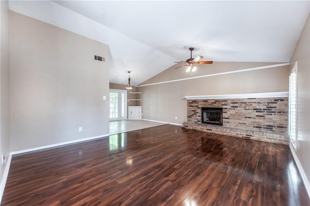 unfurnished living room with ceiling fan, dark hardwood / wood-style flooring, lofted ceiling, and a fireplace