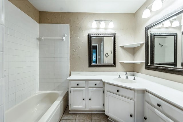 bathroom with tile patterned flooring, tiled shower / bath combo, and vanity